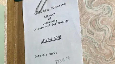 Leeds City Council A scrap of paper reading the words: "Leeds City Libraries; Library of Commerce, Science and Technology; Special Loan; Date due back: 22 March 1976. A paperclip sits at the top of the paper.