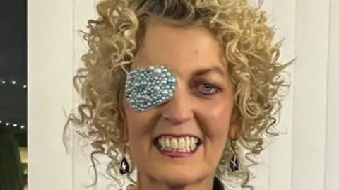 Deborah wearing an eye patch made with pearls