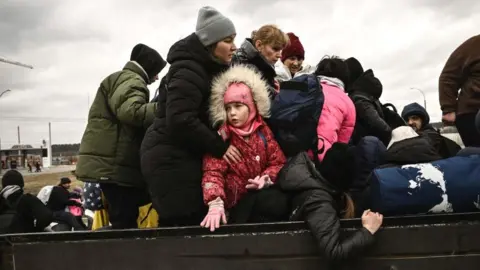 Getty Images A child looks on as residents evacuate the city of Irpin, northwest of Kyiv, 5 March 2022