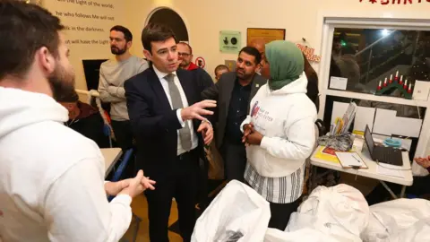 Getty Images Andy Burnham speaking to homeless volunteers