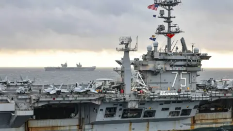 MOD USS Harry S.Truman (foreground) with F/A-18E Super Hornet, Grumman E-2 Hawkeye and Sikorsky CH-53E Super Stallion on deck, HMS Prince of Wales (Background)