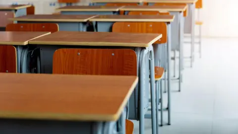 A row of desks in a school classroom.