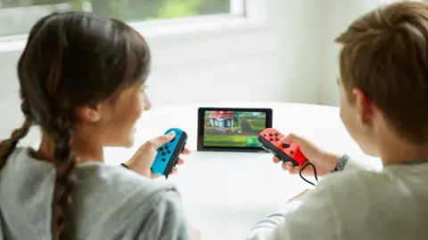 The Pokemon Company Two kids play on game console