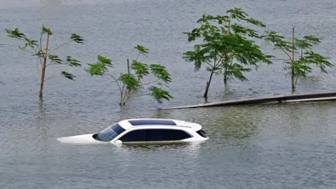 A car is stranded on a flooded street in Dubai following heavy rains on April 18, 2024.