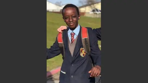 Social Media A young Axel Rudakubana pictured in school uniform in front of a field with another pupil's arm around his shoulder