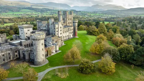 Paul Harris | Vista de drones de National Trust del Castillo de Penrhyn de piedra blanca contra el campo verde galés 
