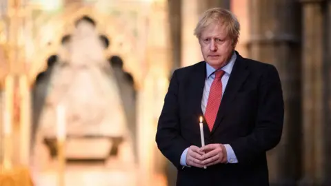 PA Media Prime Minister Boris Johnson prepares to light a candle at the Grave of the Unknown Warrior in Westminster Abbey in London, ahead of commemorations to mark the 75th anniversary of VE Day