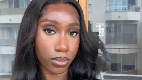 Theresa a 24-year-old woman taking a selfie with a neutral expression