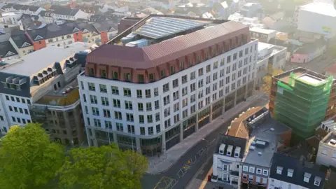 BBC An aerial view of Jersey's government building. It shows a large multi-storey white building.
