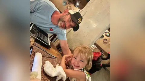 Sarah Rimmer Mr Rimmer and his younger daughter smiling.