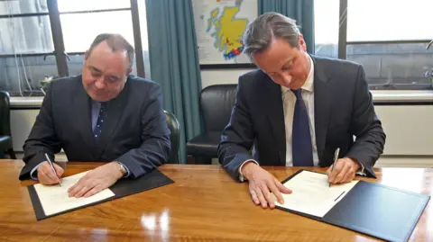 PA Media Prime Minister David Cameron (right) and Scotland's First Minister Alex Salmond (left), sign a referendum agreement, during a meeting at St Andrews House in Edinburgh.