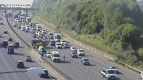 Emergency services are at the scene in lanes three and four of the M25 anticlockwise. The area has been blocked off by cones. 