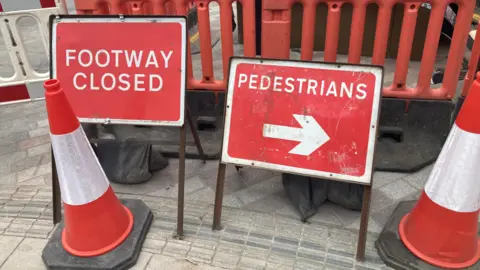 Traffic cones and signage indicating a closed footpath in Northampton town centre