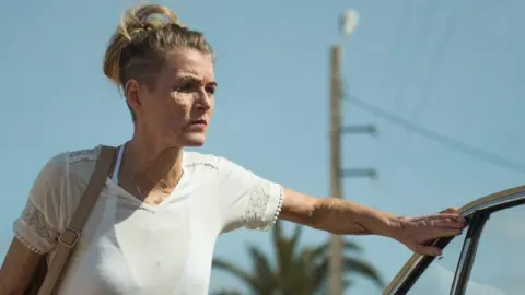 MODERN FILMS Vicky Knight posing in the film, leaning on a car door