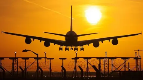 Getty Images airplane-landing-at-sunset