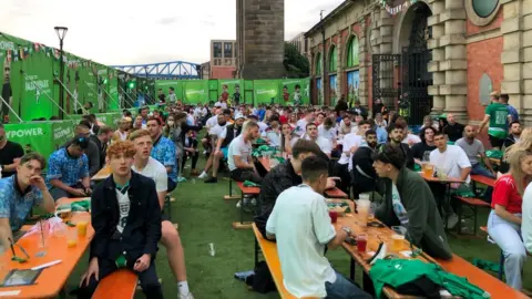 PA Media Fans at fan park watch the big screen