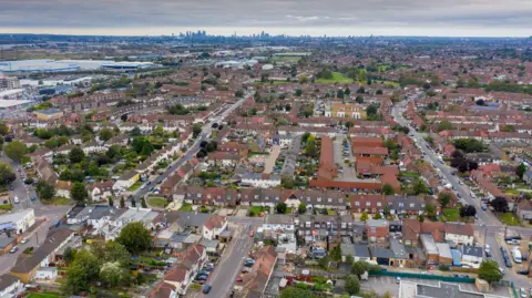 Getty Images A aerial view of a town on the edge of London with the skyscrapers of the City visible in the distance. 