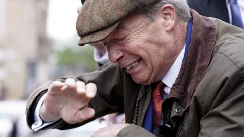 Nigel Farage flinches after an object is thrown at him.