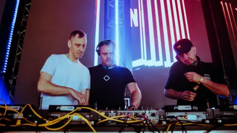 Alastair Brookes Three technicians on stage