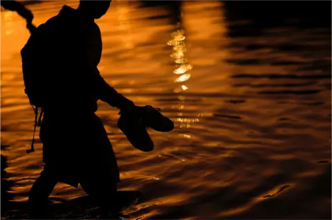 Reuters An asylum-seeking migrant crosses the Rio Bravo river, the border between the United States and Mexico, to request asylum in El Paso, Texas, U.S., as seen from Ciudad Juarez, Mexico December 21, 2022.