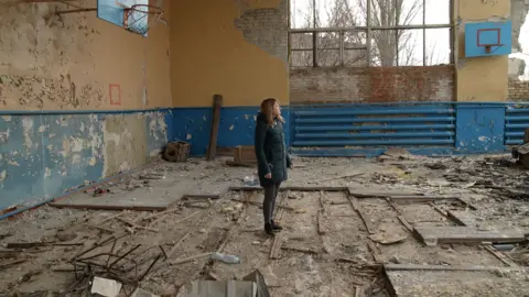 BBC/XAVIER VANPEVENAEGE Mariya surveys a destroyed gym hall