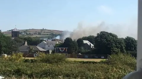 Sharon Lampard Smoke rising near houses
