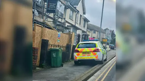 Aaran Lennoz Road with a police car on it