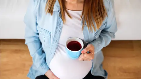 Getty Images Pregnant woman with cup