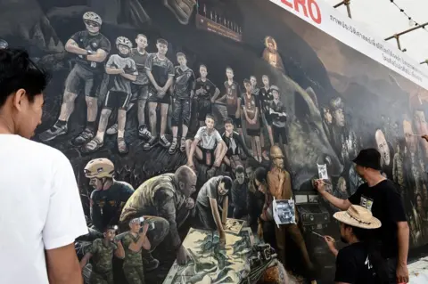 Getty Images Artists work on an art mural at Art Bridge gallery in Chiang Rai, Thailand