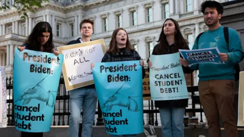 Getty Images Protestors urge Mr Biden to pass a student loan forgiveness plan