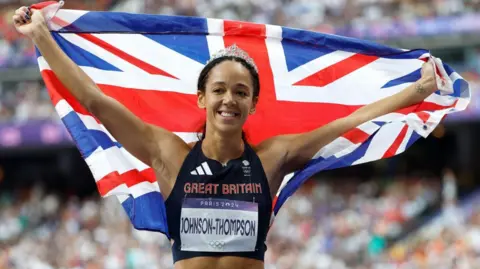 FRANCK ROBICHON/EPA-EFE/REX/Shutterstock Katarina Johnson-Thompson celebrating while holding a Union Flag at the Paris 2024 Olympic Games