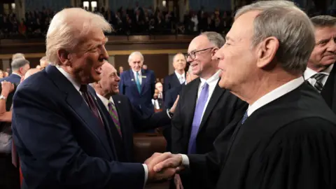Getty Images President Trump shakes the hand of Chief Justice John Roberts in March 2025