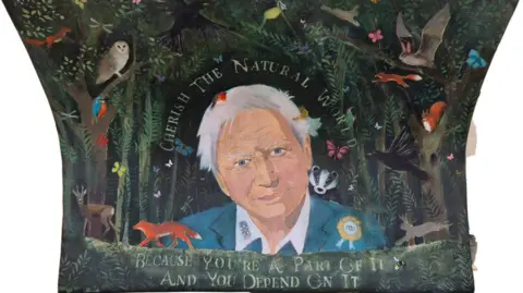 Supplied The book bench features a portrait of Sir David alongside images of iconic British wildlife such as foxes, hares and birds, and a quote which reads "Because you're a part of it and you depend on it".