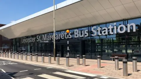 BBC The glass front of the bus station with its name in large silver letters on the exterior