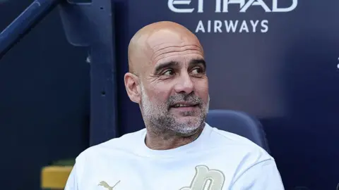 Pep Guardiola sat in the dugout at Etihad Stadium during his time in charge of Manchester City