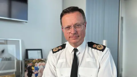 Robin Smith sat at his desk smiling at the camera.