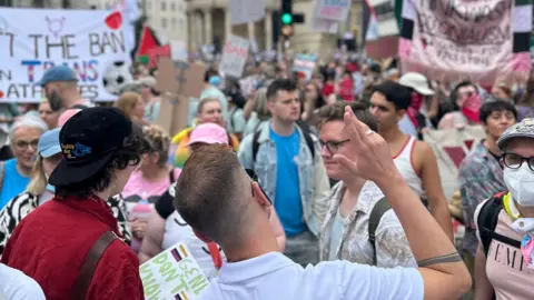 PA Media Lots of different people taking part in London Trans+ Pride. Some banners can be seen in the background