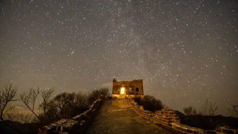 Getty Images Hujan meteor Quadrantid terlihat di langit malam di atas Tembok Besar pada 4 Januari 2025 di Beijing, Tiongkok.