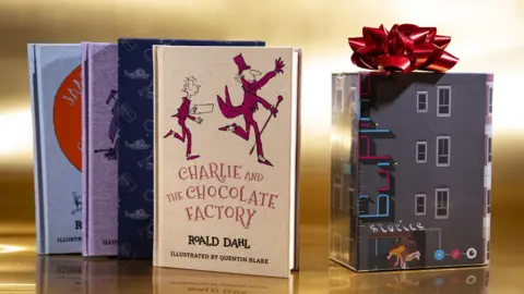 Getty Images A box set of Roald Dahl classics is placed on a table with a gift box. Charlie and the Chocolate Factory is illustrated by Quentin Blake.