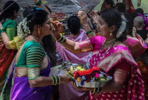 DIVYAKANT SOLANKI / EPA Hindu women perform rituals around a banyan tree during the Vat Savitri (also called Vat Purnima) festival in Bhayander, outskirts of Mumbai, India, 14 June 2022