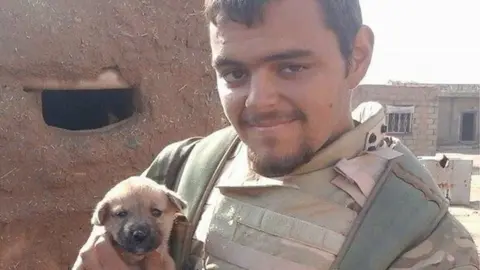 Facebook Aiden Aslin is seen wearing military uniform and holding a puppy