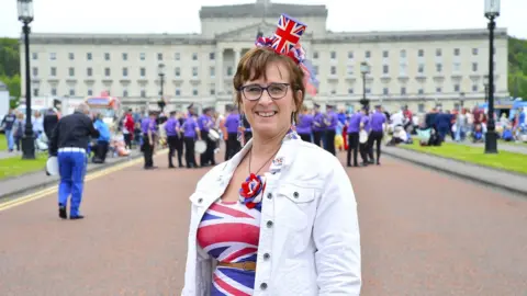 Pacemaker A woman dressed in a Union Jack dress and matching top hat headband outside Stormont