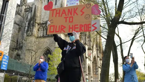 Getty Images A woman holds a sign in the US thanking emergency workers