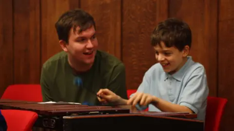 Turtle Key Arts A child being taught music during the Turtle Opera project