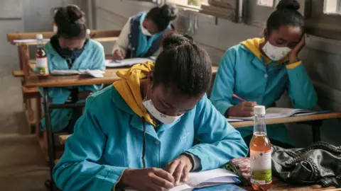 AFP Malagasy schoolchildren at their desks with Covid-Organics bottles next to them - April 2020