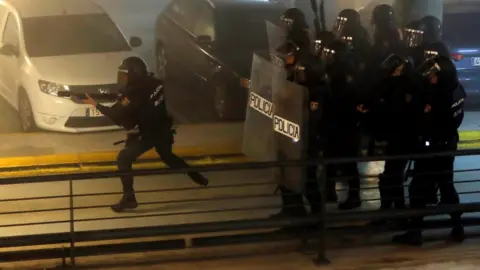 EPA Spanish National Police riot officers charge at demonstrators during the rally called by the group called "Tsunami Democratic" (Democratic Tsunami) for "shutting-down" Barcelona-El Prat international airport