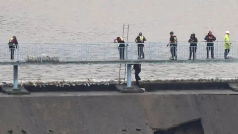 Reuters Workers put sandbags on reservoir edge