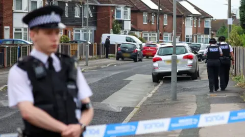 Reuters Police officers near to the scene on Kingsheath Avenue