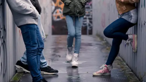 Young people stood on a bridge