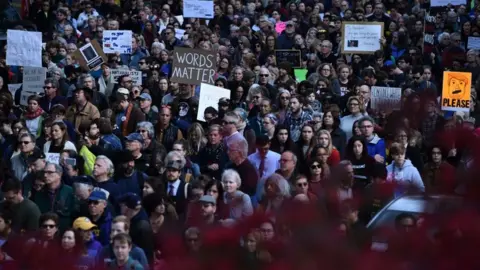 Getty Images Protesters held signs saying 'words matter' and 'renounce white nationalism'
